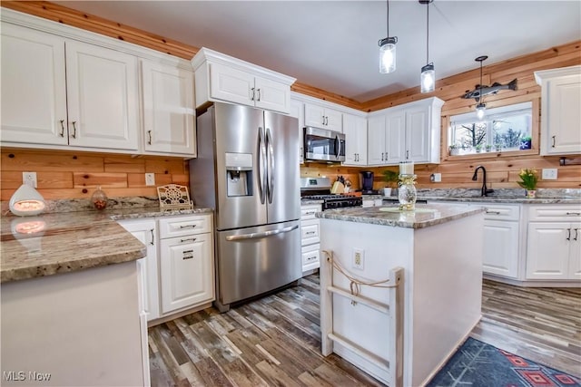 kitchen with white cabinetry, wood finished floors, and stainless steel appliances