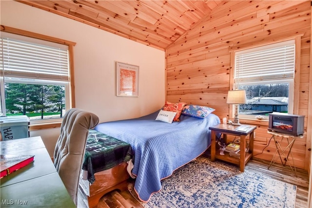 bedroom with wood ceiling, wood finished floors, wood walls, and lofted ceiling