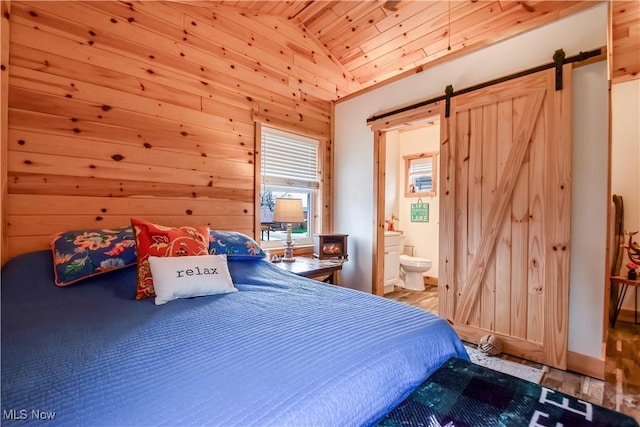 bedroom with wooden ceiling, a barn door, ensuite bath, wood finished floors, and lofted ceiling