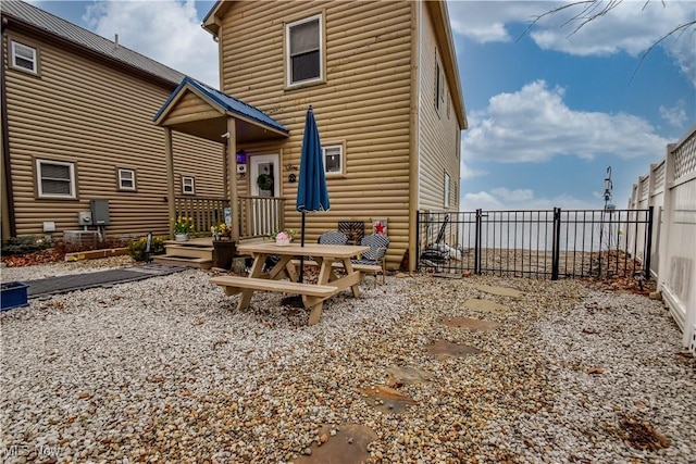 rear view of house with a fenced backyard and log veneer siding