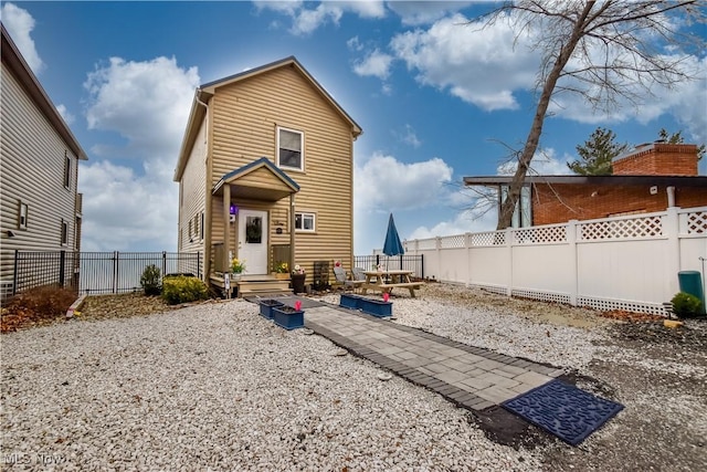 rear view of house featuring a fenced backyard and log veneer siding