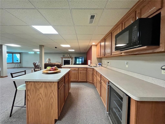 11955 Epping Trl, Chardon, OH 44024 - kitchen with wine cooler, black microwave, light countertops, a kitchen bar, and open floor plan