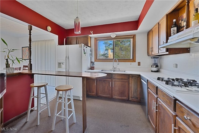 1863 Beaver Trl, Mineral Ridge, OH 44440 - kitchen with a sink, a kitchen breakfast bar, white appliances, a textured ceiling, and pendant lighting