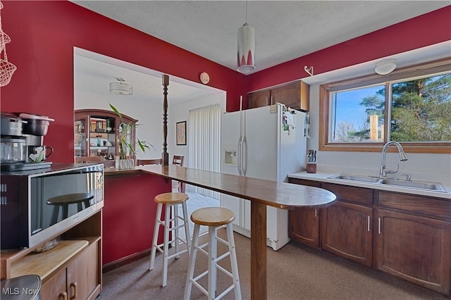 1863 Beaver Trl, Mineral Ridge, OH 44440 - kitchen featuring a sink, stainless steel microwave, light colored carpet, and white fridge with ice dispenser