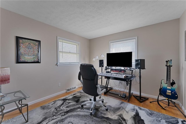 1863 Beaver Trl, Mineral Ridge, OH 44440 - office area featuring visible vents, baseboards, wood finished floors, and a textured ceiling
