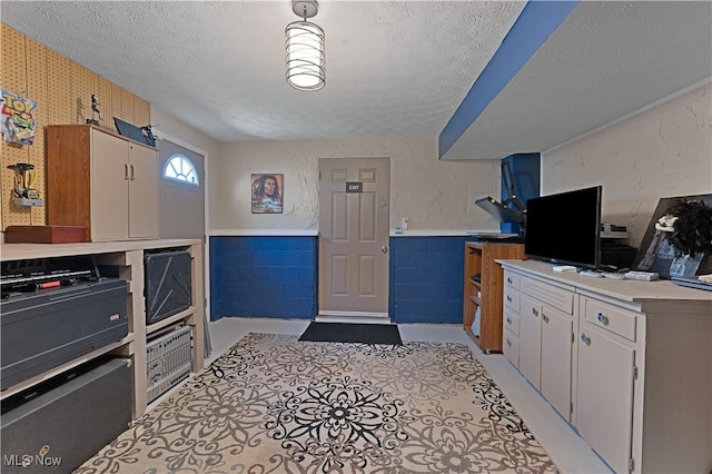 1863 Beaver Trl, Mineral Ridge, OH 44440 - kitchen featuring a textured ceiling, light countertops, and wainscoting