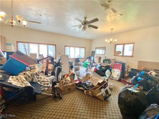 interior space featuring ceiling fan with notable chandelier and carpet flooring