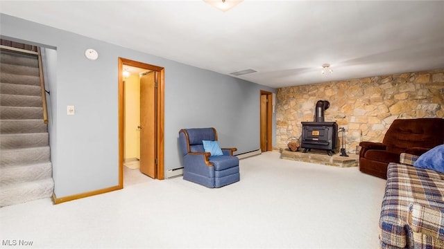 165 Reservoir Rd, New Concord, OH 43762 - carpeted living area with a wood stove, a baseboard radiator, baseboards, and stairs