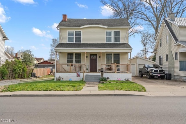 view of front facade featuring a front yard, a detached garage, a porch, fence, and an outbuilding