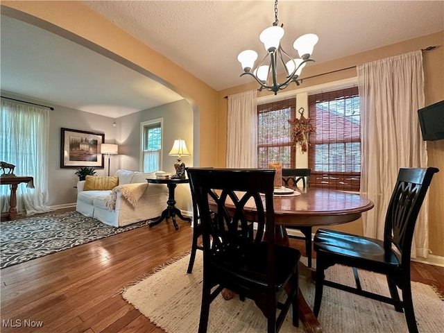 835 John St, Niles, OH 44446 - dining space with a chandelier, arched walkways, baseboards, and wood finished floors