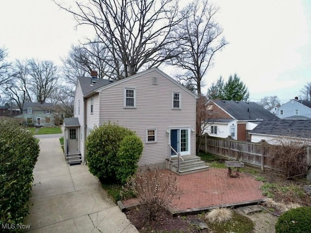 835 John St, Niles, OH 44446 - rear view of house featuring entry steps, fence, and a chimney