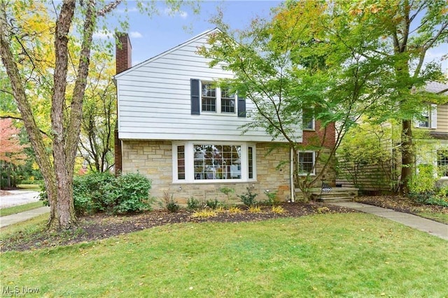 4090 Silsby Rd, University Heights, OH 44118 - view of front of property featuring stone siding, a chimney, and a front yard
