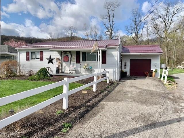 1317 Josephine St, Toronto, OH 43964 - ranch-style home featuring an attached garage, asphalt driveway, metal roof, and a porch