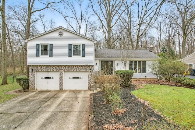 split level home with a front yard, a garage, brick siding, driveway, and roof with shingles