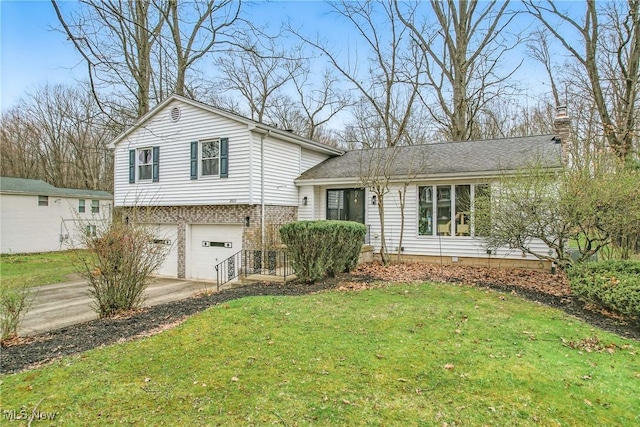 split level home with a chimney, a garage, a front yard, and driveway
