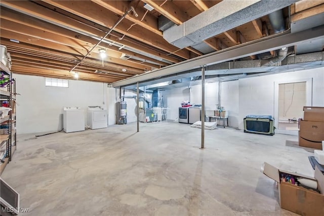 basement with heating unit, washing machine and dryer, and water heater