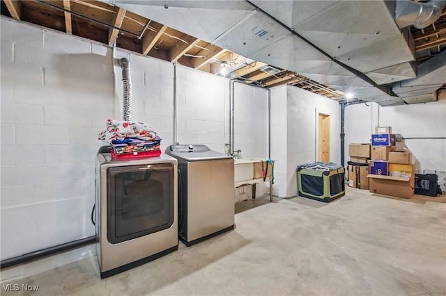 unfinished below grade area with a sink, independent washer and dryer, and concrete block wall