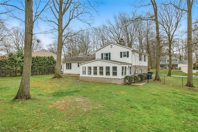 rear view of property with fence, a lawn, and a chimney