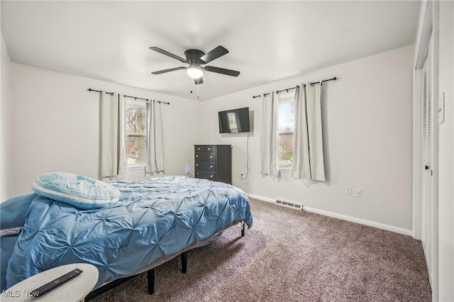 carpeted bedroom featuring visible vents, baseboards, and a ceiling fan
