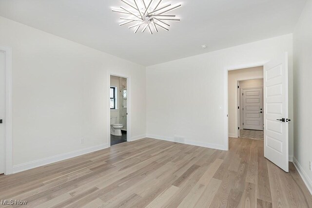 2762 Rocky Ridge Dr, Westlake, OH 44145 - spare room with a notable chandelier, light wood-type flooring, and baseboards