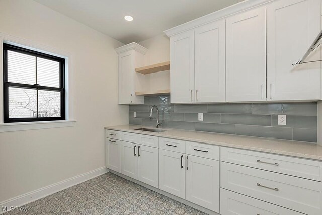 2762 Rocky Ridge Dr, Westlake, OH 44145 - kitchen with tasteful backsplash, open shelves, light countertops, a sink, and baseboards