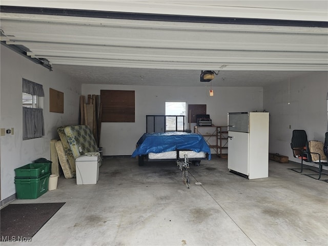 3509 11th Ave, Vienna, WV 26105 - garage featuring electric panel, a garage door opener, and freestanding refrigerator