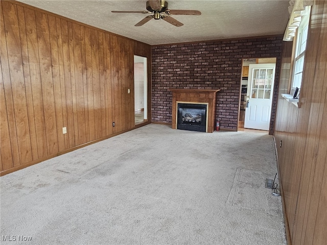 3509 11th Ave, Vienna, WV 26105 - unfurnished living room featuring carpet flooring, wooden walls, a brick fireplace, and ceiling fan