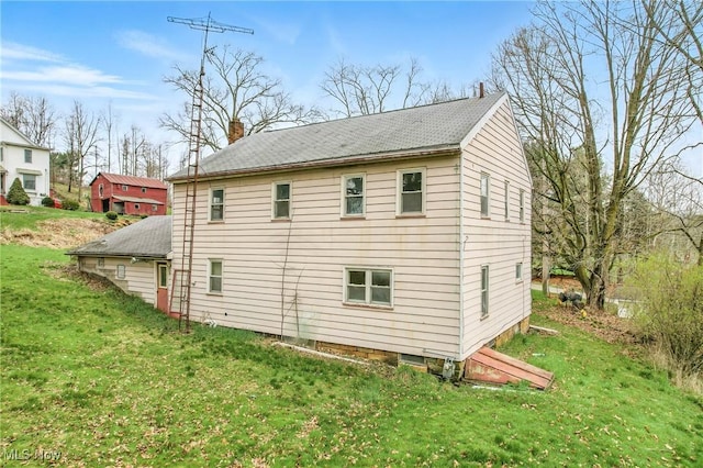 rear view of property featuring a yard and a chimney