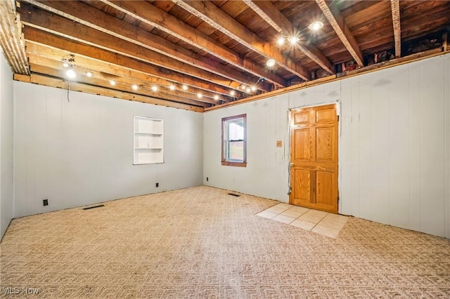basement with wood ceiling, visible vents, and carpet