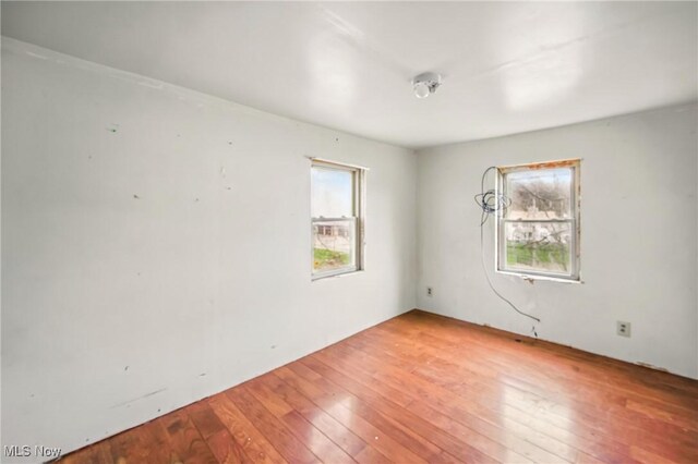 unfurnished room with plenty of natural light and hardwood / wood-style floors