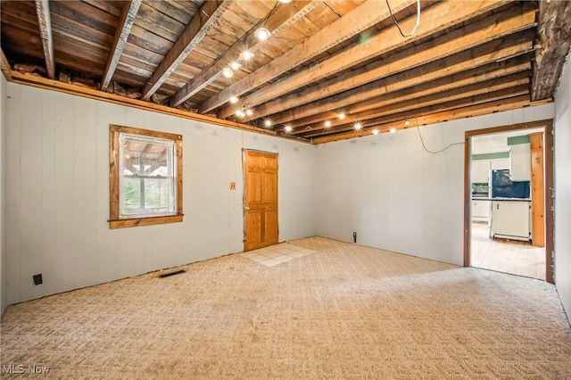 below grade area featuring visible vents, fridge, carpet, and wood ceiling