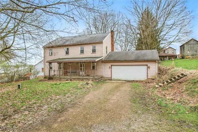 traditional-style house with a porch, driveway, and a garage