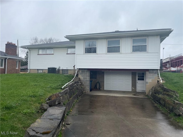 301 E Howard St, Girard, OH 44420 - view of front of house with a front yard, central air condition unit, a garage, and concrete driveway