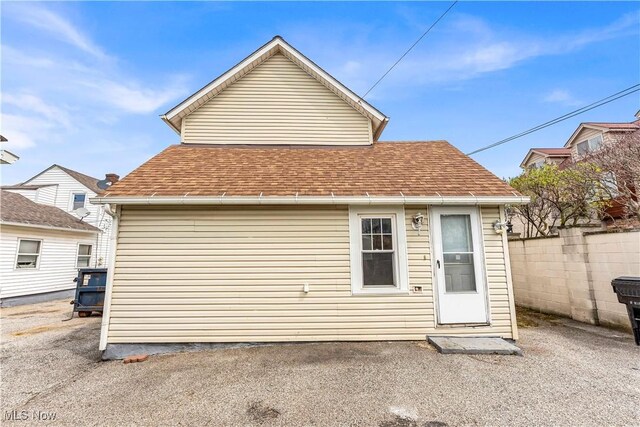 1244 W 69th St, Cleveland, OH 44102 - back of property with a shingled roof and fence