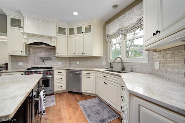 kitchen with a sink, white cabinetry, and stainless steel appliances