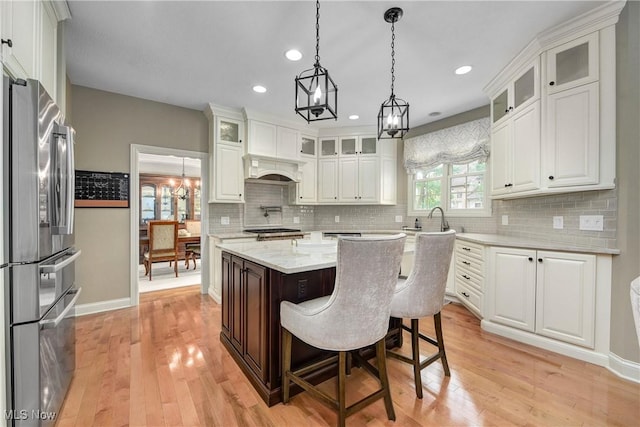 kitchen featuring white cabinetry, tasteful backsplash, and freestanding refrigerator