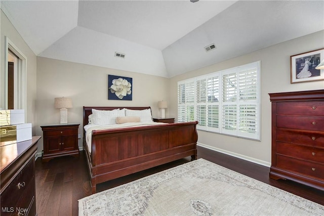 bedroom with dark wood-style floors, vaulted ceiling, and visible vents