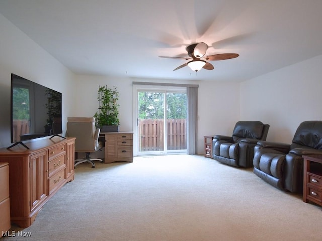 living area featuring light carpet and a ceiling fan