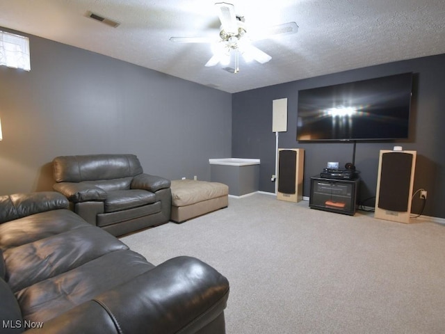 living area with carpet, visible vents, baseboards, and ceiling fan