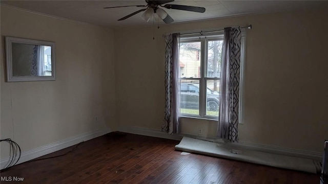 spare room featuring dark wood-style flooring, baseboards, and a ceiling fan