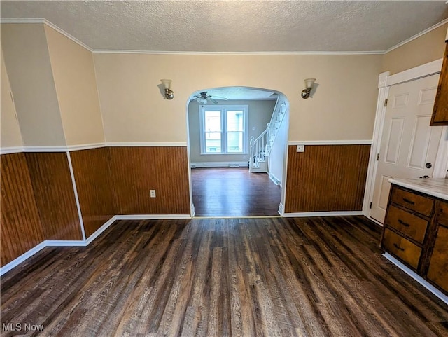 1636 W 8th St, Ashtabula, OH 44004 - unfurnished dining area with arched walkways, dark wood-style flooring, a textured ceiling, ceiling fan, and a wainscoted wall