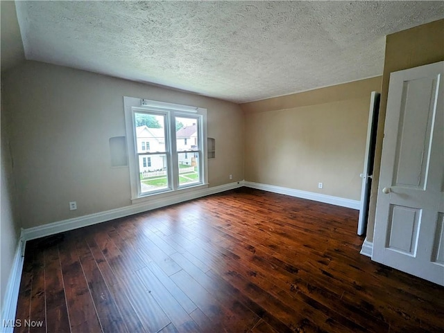 1636 W 8th St, Ashtabula, OH 44004 - empty room featuring baseboards, lofted ceiling, a textured ceiling, and dark wood-style flooring