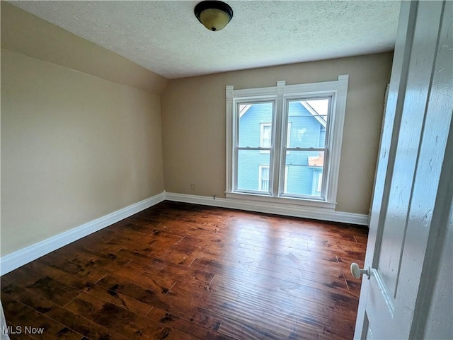 1636 W 8th St, Ashtabula, OH 44004 - empty room with dark wood finished floors, a textured ceiling, baseboards, and lofted ceiling