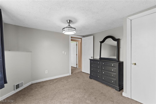 unfurnished bedroom featuring visible vents, baseboards, carpet floors, and a textured ceiling