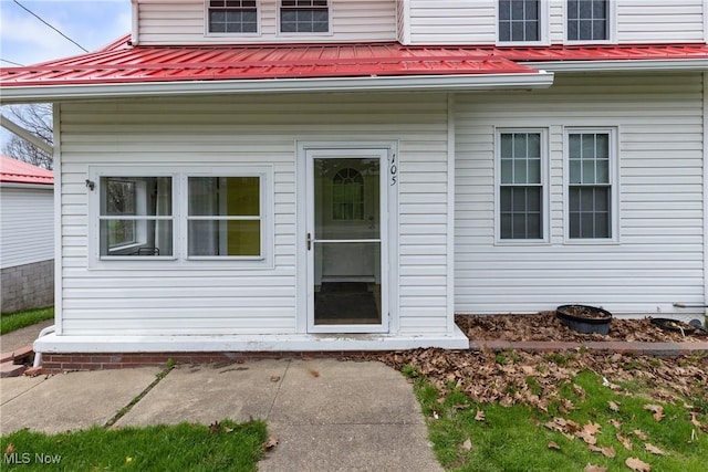 doorway to property featuring metal roof