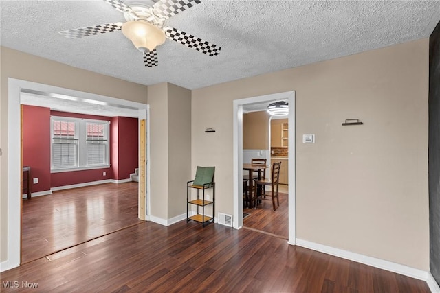 spare room featuring a textured ceiling, wood finished floors, and visible vents