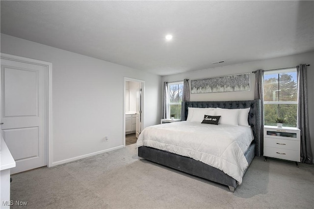 bedroom featuring baseboards, visible vents, ensuite bathroom, and carpet flooring