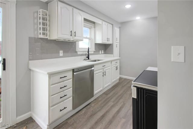 kitchen featuring a sink, light wood-type flooring, stainless steel dishwasher, and range