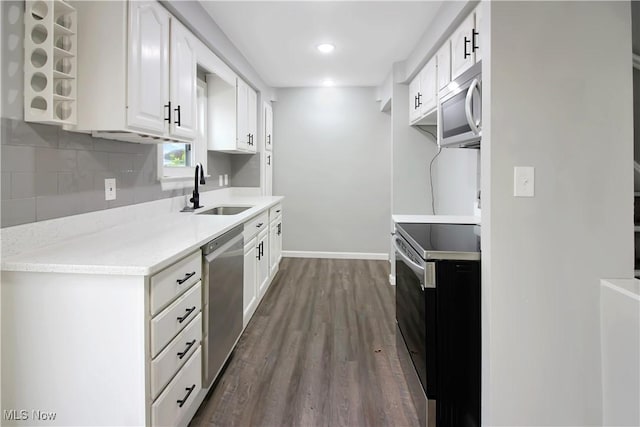 kitchen with tasteful backsplash, dark wood-style flooring, light countertops, appliances with stainless steel finishes, and a sink