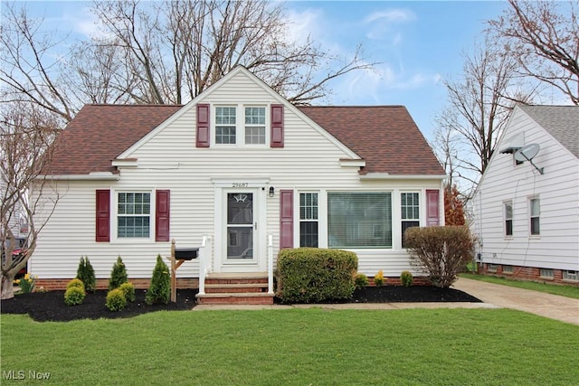 view of front facade featuring a front yard and roof with shingles